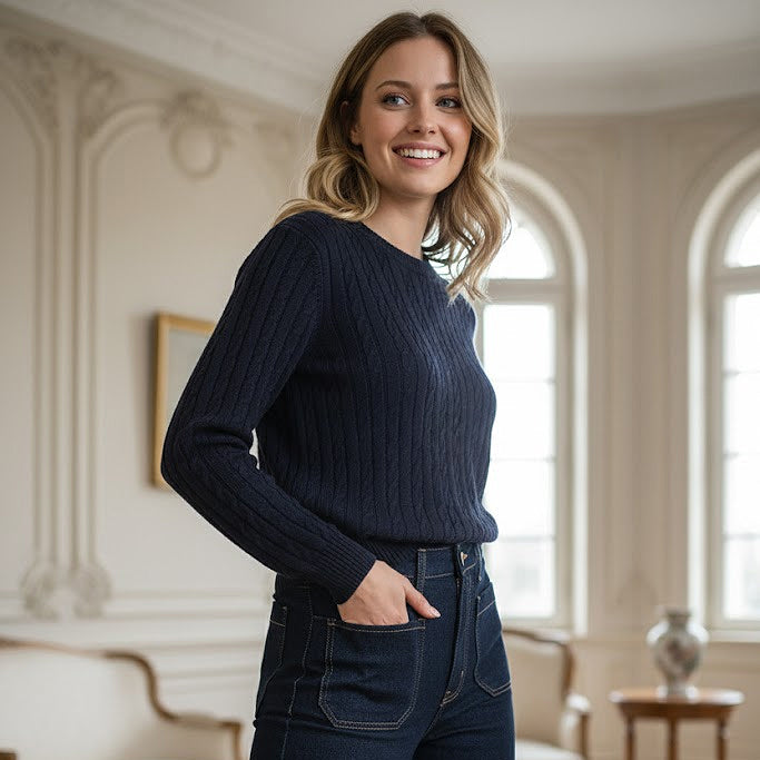 Preppy girl wearing a navy blue sweater and jeans in an elegant room with arched windows.