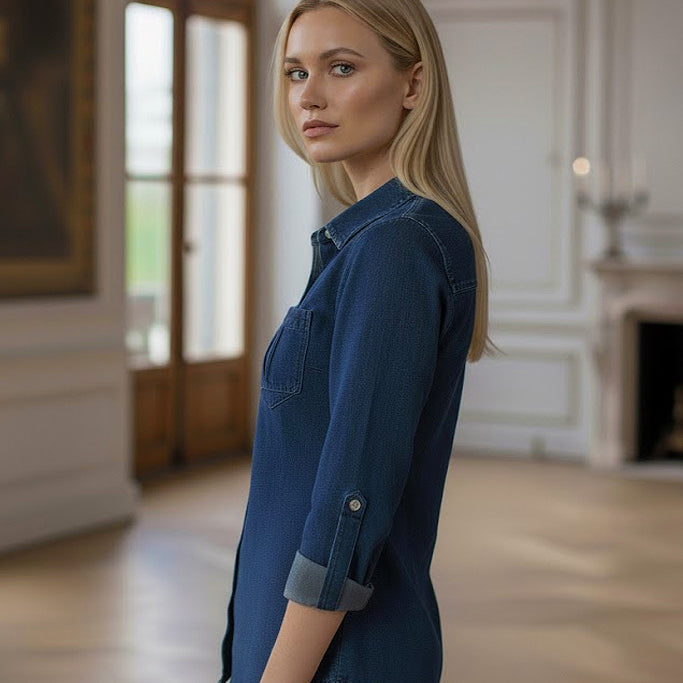 Woman wearing a blue denim shirt in an indoor setting